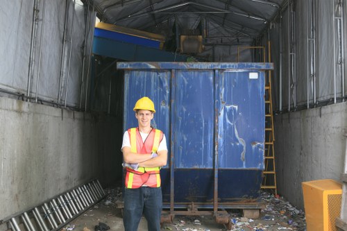 Operatives in high-visibility PPE loading sealed commercial waste containers